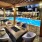pool deck lounge area with landscaping, ample seating, colorful couch decor and spacious walkability