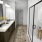 bathroom with a large mirror and walk-in shower