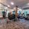 fitness center in a bright well-lit room showing plenty of equipment and modern decor in a large, spacious room