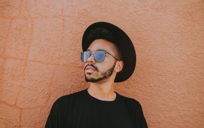 lifestyle image of a young man with sunglasses and a stylish hat